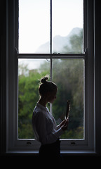 Image showing Woman, feather and window for writer in home for idea and creative with author, inspiration and learning. Female artist, writing and shadow with thinking, fashion and mysterious editor for literature