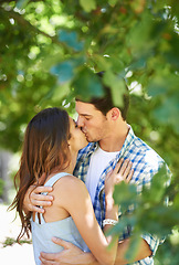 Image showing Love, kiss and holiday with couple in park for romance, bonding and summer vacation. Affection, commitment and relax with man and woman hugging on date in nature for care, support and relationship