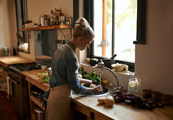 Image showing Woman, chef and washing food for hygiene in the kitchen sink at home for cooking. Female person, prepare and cleaning vegetables for meal and nutrition or rising in water for a healthy diet