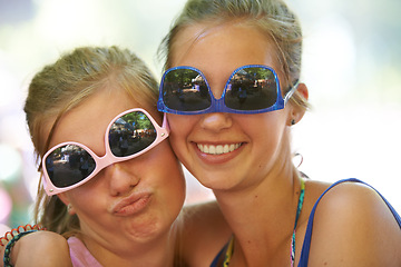 Image showing Women, sunglasses and silly portrait at festival in nature, excited and reunion for bonding together. Friends, funny face and relax for celebration in summer on holiday and care at concert outdoor