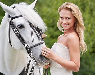 Image showing Wedding, woman and portrait with horse outdoor for celebration, marriage and confidence in countryside. Bride, person and stallion on lawn in field with smile, dress and animal at ceremony in nature