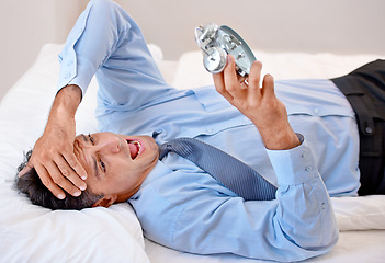 Image showing Businessman, alarm clock and stress for waking up in bed, anxiety and late for business. Male person, frustrated and annoyed for time at home, professional and sleepless or lazy and worry in bedroom