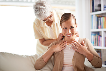 Image showing Portrait, necklace and senior mother with woman for present, gift and surprise in living room. Family, love and happy daughter with mom giving pearls on sofa for celebration, birthday and bonding