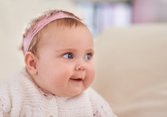 Image showing Happy, baby girl and face in a home with a calm, relax and sweet infant in a living room. Youth, child and house with toddler clothing in the morning ready for a nap on the sofa with joy and headband