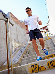 Image showing Man, stairs and earphones for running outdoors, sports and athlete for performance training in city. Male person, full body and sunglasses for workout in town, cardio and listen to music for exercise