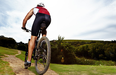 Image showing Fitness, bike and man cycling in countryside for training, cardio or adventure on off road path. Exercise, sports and wellness with cyclist person in nature for health, workout or challenge from back