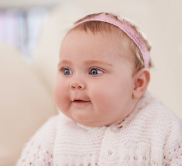 Image showing Happy, baby and face in a home with a cute, relax and sweet infant in a living room. Youth, child and house with toddler clothing in the morning ready for play on the sofa with joy and headband