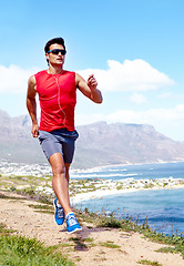 Image showing Man, beach and earphones for running outdoors, sports and athlete for performance training by sea. Male person, full body and sunglasses for workout in nature, cardio and listen to music for exercise