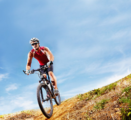 Image showing Nature, fitness and man athlete with bicycle in park for marathon, race or competition training. Blue sky, sports and male cyclist riding bike for cardio workout or exercise in outdoor forest.