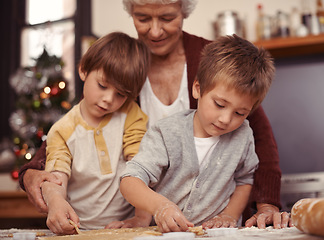 Image showing Happy family, biscuits and baking in kitchen with cutter, home and learning of dessert cake with love. Grandma, teaching and boys of cookies on table, care and together on christmas holiday in house