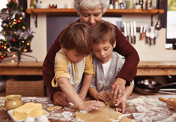 Image showing Grandmother, learning and kids baking at Christmas in kitchen, teaching and boys bonding together in family home. Grandma, children and cooking at xmas and brothers making cookies on holiday at table