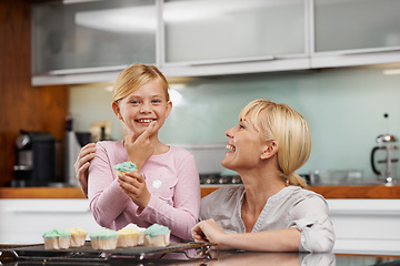 Image showing Happy, mom and child with cupcake in kitchen and portrait of baking together in home to relax. Family, bonding and kid smile with mother, excited for eating cake, sweets or enjoy food in house