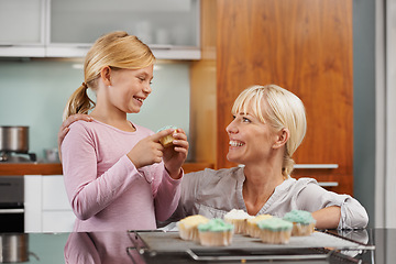 Image showing Happy, mom and child with cupcake in kitchen and learning about baking together in home to relax. Family, bonding and kid smile with mother, excited for eating cake, sweets or enjoy food in house