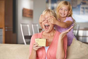 Image showing Mothers day, surprise and daughter with gift, sofa and smile in house while closing eyes and excited. Mom, kid and present on sofa, home and happy for birthday or playing peekaboo for love and fun