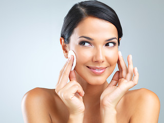 Image showing Cotton pad, beauty and woman cleaning makeup from face, dermatology and skincare with facial on grey background. Cosmetic product, healthy skin and wipe for cleanse, wellness and glow in studio