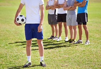 Image showing Person, team and hand holding soccer ball for game, training and competition with fitness. People, group and football player with coach, captain or leader for sports, exercise or workout for contest