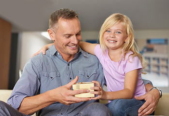 Image showing Home, portrait and child with present for father on birthday or giving a box for special event. Family, gift and offer dad package and hug to show gratitude, care or kid with kindness in living room