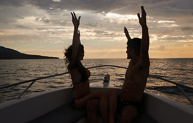 Image showing Couple, freedom and sunset on boat with silhouette, happy with vacation and travel to Italy for the ocean and fresh air. Romantic adventure for love, bonding and excited with arms raised in transport