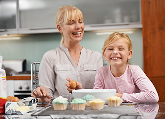 Image showing Baking, cupcake and portrait with child and mom in kitchen to relax in home together on holiday. Family, bonding and kid smile with frosting on face and mother laughing and enjoy food prep in house