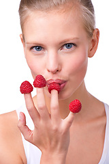 Image showing Portrait, breakfast and raspberries on fingers of woman in studio isolated on white background for diet. Face, health and food on hand of young person eating fruit for weight loss, detox or nutrition