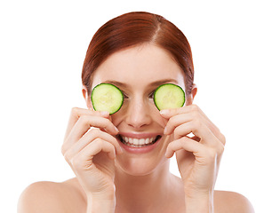 Image showing Woman, smile and cucumber in studio for skincare with natural beauty, shine and hydration benefit on white background. Face, cosmetics and hand with fruit for vitamin c, dermatology and self care