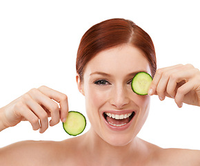 Image showing Woman, smile and face with cucumber in studio for skincare, beauty and self care benefit on white background. Portrait, cosmetic and hands with fruit for vitamin c, dermatology and natural glow