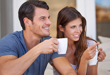 Image showing Couple, watching tv and point with coffee on sofa for questions, conversation or choice in home. People, man and woman on lounge couch with streaming, movies and hug with drink in morning at house