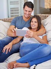 Image showing Happy couple, hug and sofa with tablet for entertainment, movie or social media at home. Man and woman lying in relax with smile on technology for online streaming, series or show in living room