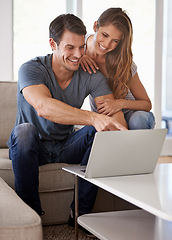 Image showing Couple, home and sofa with laptop, bonding and entertainment in living room with smile and laugh. Man, woman and couch with embrace, relax and love while pointing at tech in lounge at house