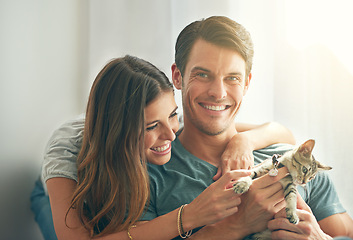 Image showing Couple, kitten and smile in home with care, hug and love for bonding with pet in living room. People, man and woman with kindness, portrait and excited for cat in lounge for animal adoption at house