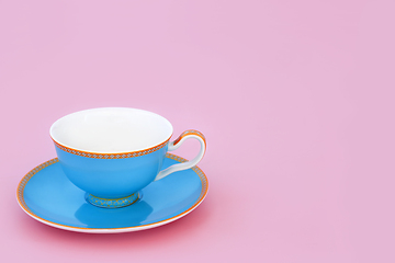 Image showing Blue and Gold Porcelain Tea Cup on Pink Background