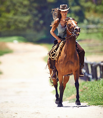 Image showing Happy woman, countryside and cowgirl with horse for ride, journey or outdoor adventure in nature. Female person or western rider with hat, saddle and animal stallion or riding pet at ranch or farm