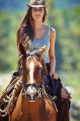 Image showing Woman, portrait and cowgirl with horse in countryside for ride, journey or outdoor adventure in nature. Female person or western rider with hat, saddle and animal stallion at ranch, farm or stable