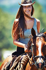 Image showing Happy woman, countryside and portrait with cowgirl in horse riding for journey or outdoor adventure in nature. Female person or western rider with hat, saddle and animal stallion at ranch or farm