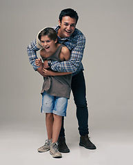 Image showing Happy father, portrait and child laughing with hug for love, care or support in fashion on a gray studio background. Dad playing with son or kid in happiness for parenting or bonding on mockup space