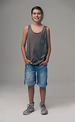 Image showing Happy boy, portrait and fashion with style in denim shorts or jeans on a gray studio background. Male person, child or teenager with summer clothing or cool stylish outfit with winter cap on mockup