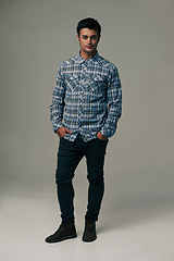 Image showing Handsome man, portrait and fashion with style or jeans on a gray studio background. Male person, adult or young model with casual clothing or stylish outfit in confidence on mockup or apparel space