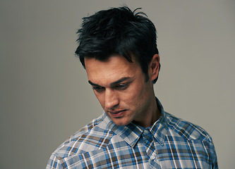 Image showing Thinking, fashion and face of man on gray background with confidence, pride and serious. Looking down, wondering and isolated person with trendy clothes, casual outfit and style for studio closeup