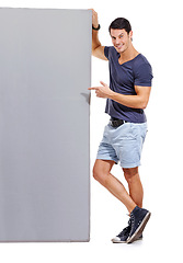 Image showing Man, pointing at mockup space and advertising signage, portrait with announcement or news on white background. Billboard, poster and sign with information, communication and about us promotion