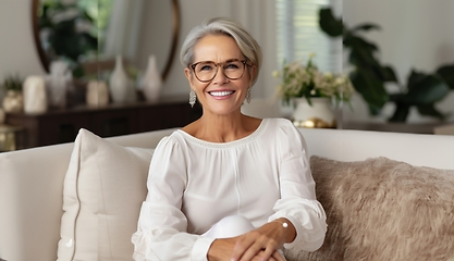 Image showing In her sunlit living room, the modern elderly woman exudes sophistication, wearing glasses, creating a chic and cozy atmosphere.