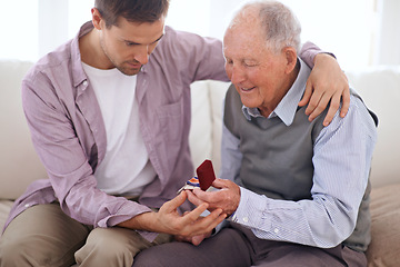 Image showing Father, son and medal at home, smile and happy relationship in house. Family bonding, proud dad and child on sofa sitting together, elderly man and giving award at living room after retirement