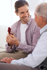 Image showing Senior dad, son and medal for surprise present, support and congratulations with celebration and bonding at home. Men in living room, family with reward or award as gift for happiness and gratitude