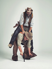 Image showing Men, cowboy or playing as criminal in studio, outlaw or wild west character with fighting for revolver. Texas guys, bandit and weapon for war in western and people with leap frog by white background