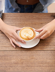 Image showing Person hands, coffee cup and foam in cafe espresso, caffeine and latte art on wooden table. Cappuccino mug, hot milk and cream for taste with drink, fresh and warm beverage in restaurant for break