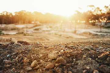 Image showing Sky, sunset and trees in nature with rocks in roadway for outdoor, countryside and lens flare. Landscape, dirt road and tough terrain for extreme sports, competition and sunshine in Switzerland.