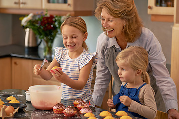 Image showing Mature woman, children and smile for baking in retirement for family, fun and bonding at home. Happy, female pensioner and girl with cupcake, laugh and icing for creative fun together in kitchen