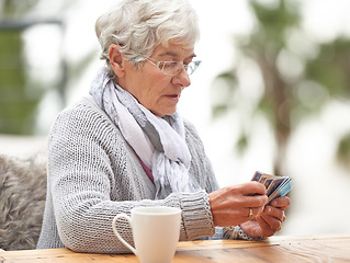 Image showing Elderly woman, coffee and card games at table on bokeh background for retirement, old age and idea. Senior person or grandma with deck in hand for thinking, playing poker and relax or hobby outdoors