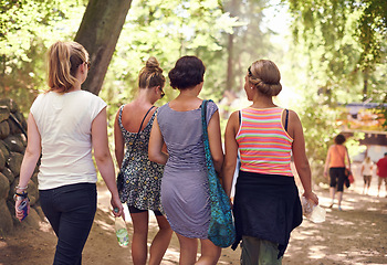 Image showing Festival, party and woman friends walking outdoor in forest or woods together for event and celebration. Social gathering, show or performance with group of people in nature as audience from back