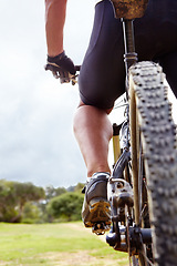 Image showing Cyclist, feet and closeup on bike in nature for training, race or workout for adventure, fitness and health. Person, athlete and bicycle for triathlon, speed and balance in bush, field and outdoor
