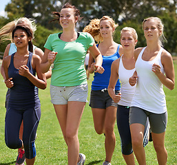 Image showing Group, women and friends with running on field for health, fitness and training with diversity in summer. People, exercise and runner in team on grass for workout, wellness or together in Los Angeles